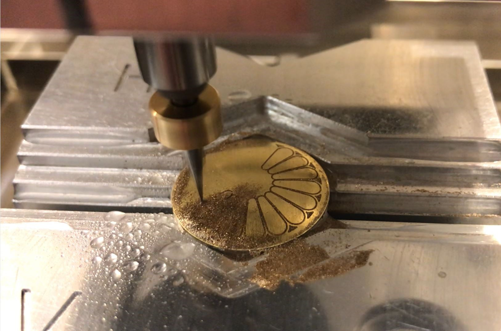 Load video: Engraving St. Michael Jewelry Pendant  Milling and engraving of curved gold rounds with simple 2D drawings. No problem thanks to the patented measuring system in Veromill. The engraving machine measures the surface fully automatically. Then the 3D processing can begin.